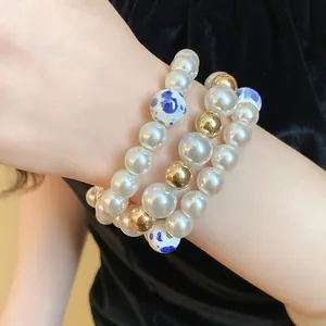 Detail view of multi-strand bracelet with pearls, gold beads, and ceramic accents