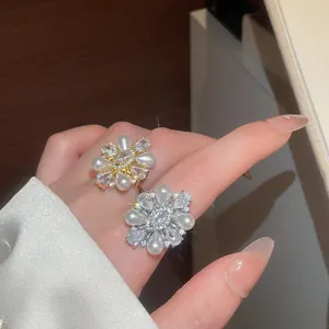 Detailansicht exquisiter Blumenringe mit Tropfenperlen und funkelnden Zirkoniasteinen