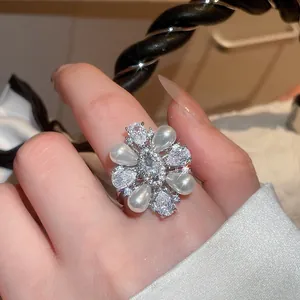 Nahaufnahme eines eleganten Blumenrings mit Wassertropfenperlen und funkelnden Zirkonia