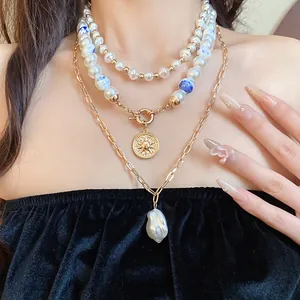 Close-up of layered vintage necklaces with ceramic beads and baroque pearl pendant