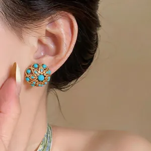 Close-up of vintage French style 18k gold plated hollow flower earrings for women