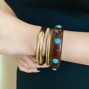 Close-up of vintage resin and gold-tone metal bangles with turquoise-colored stones