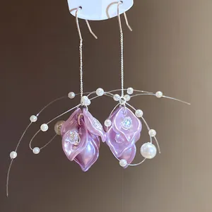 Macro view of purple petal earrings with zircon accents and delicate pearl tassels.