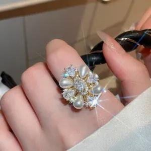Nahaufnahme eines 14-karätig vergoldeten Blumenrings mit Perlen und funkelnden Zirkonia