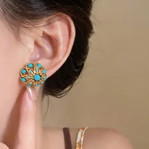 Close-up detail showing the French vintage style gold floral stud earrings on a model's ear