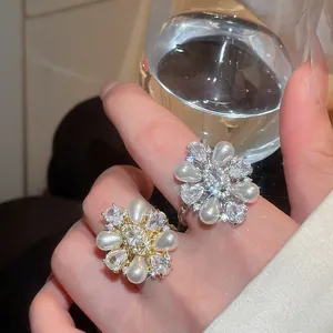 Detailansicht eleganter Blumenringe mit Tropfenperlen und funkelnden Zirkoniasteinen.