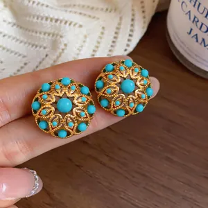 Detailed macro shot of vintage 18k gold plated flower earrings with turquoise beads