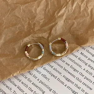 Detailed macro view of 14k gold-plated hoop earrings featuring multi-color enamel sections