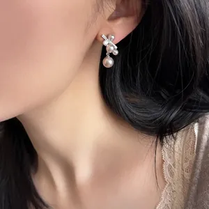 Eleganti orecchini in argento stile coreano con zirconi e perle indossati da una modella