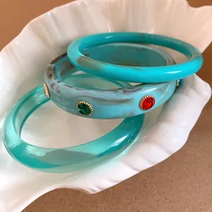 Close-up of three Bohemian resin bangles featuring turquoise marble and rhinestone details.