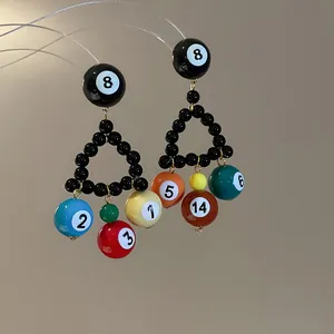 Macro view showing the colorful billiard ball charms and black bead triangle of the earring