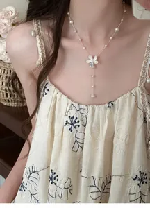 Close-up of elegant zircon flower pendant and delicate beaded pearl necklace