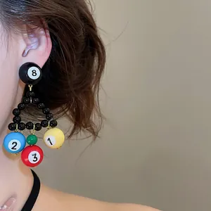 Detail view of stylish billiard ball beaded triangular earrings worn by an Asian model