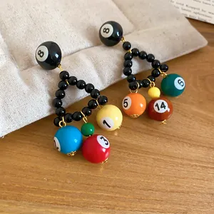 Close-up of unique black beaded triangle earrings with colorful billiard ball charms