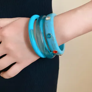 Close-up of bohemian resin bangles set featuring marble pattern and colorful rhinestones