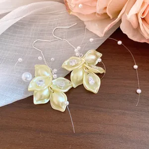 Close-up of elegant petal earrings featuring shimmering zircon and pearl tassel details