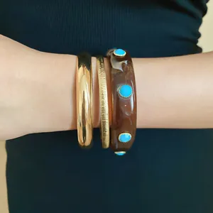 Close-up view of vintage Bohemian resin bangle with turquoise studs and gold metal bracelets