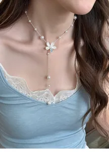 Elegant silver-tone pearl necklace featuring a sparkling zircon flower pendant on a model