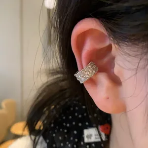 Detailed view of a silver-tone clover-shaped ear bone clip with sparkling pave-set stones.