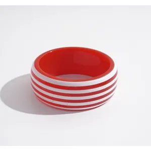 Elegante pulsera rígida de resina con rayas rojas e blancas y un diseño geométrico minimalista