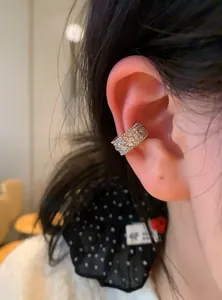 Detailed view of silver ear cuff with pavé rhinestones and interlocking pattern