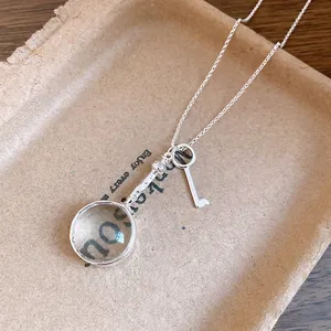 Vintage magnifying glass and key pendant necklace in silver finish