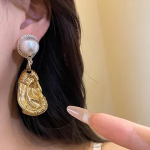 Elegante klassische goldene Perlenohrringe mit strukturierter Metalltropfenverzierung