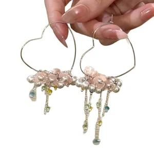 Delicate heart-shaped hoop earrings featuring colorful tassels and flower pearl accents