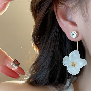 Close-up showing the elegant white resin flower drop earring with 18k gold plated finish