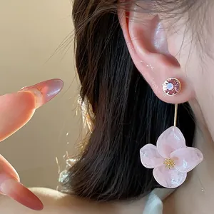 Close-up of elegant pink resin flower drop earrings with a sparkling crystal stud