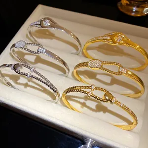 Detailaufnahme von gedrehten Knotenarmbändern mit funkelnden Zirkonen in einer Schatulle
