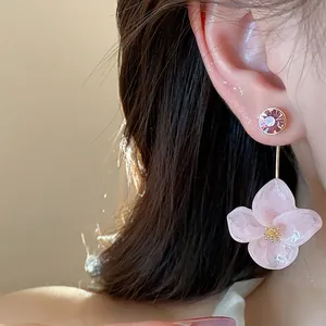 Macro view of pink resin flower earrings featuring delicate crystal stud details