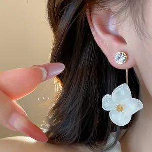 Detail of 18k gold plated resin flower earring with sparkling crystal stud