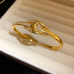 Nahaufnahme eines eleganten vergoldeten Knotenschnallen-Armreifs mit Zirkonia-Steinen