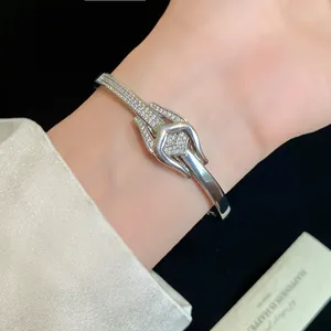 Detailansicht eines eleganten 18K vergoldeten Armreifs mit funkelndem Zirkon-Knoten