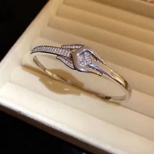 Detailansicht eines Knotenbangle-Armbands mit Zirkonia-Besatz und 18-karätiger Vergoldung