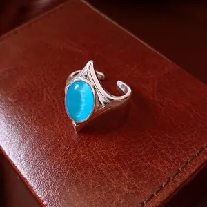 Vintage silver geometric open ring with blue cat's eye stone on brown leather box.