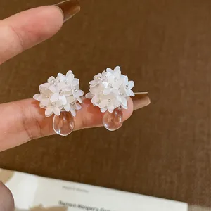 Detailansicht zarter weißer Harz-Blumenohrstecker mit transparentem Wassertropfen
