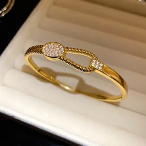 Makroansicht des 18 Karat vergoldeten Armreifs mit Zirkonia-Besatz in Schmuckschatulle