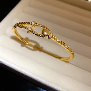 Detailaufnahme eines 18K vergoldeten Armbands mit Zirkonia-Steinen und Kordeldesign.