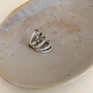 Vista dettagliata di un ear cuff in argento a quattro file con zirconi e dettaglio stella.