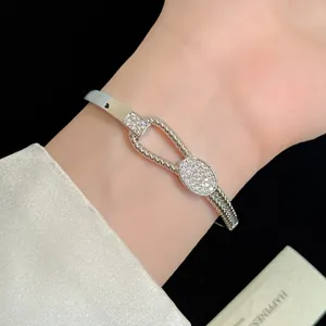 Nahaufnahme eines 18K weißvergoldeten Armreifs mit gedrehtem Knoten und Zirkonia-Steinen