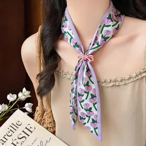 Detail showing elegant floral fabric scarf necklace with a charming pink resin bow clasp