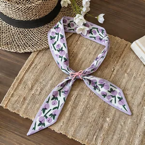 Close-up view of the lavender floral fabric necklace featuring a pink resin bow
