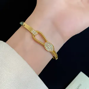Nahaufnahme des 18K vergoldeten Armreifs mit gedrehtem Knotendesign und Zirkonia