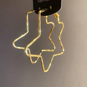 Close-up detail of 18k gold plated star-shaped hoop earrings featuring a unique textured finish