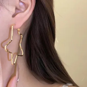 Close-up of 18k gold plated star hoop earring shown on ear for realistic wear effect