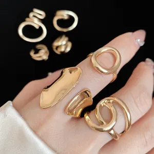 Close-up of minimalist irregular gold rings with hollow oval designs worn on a hand