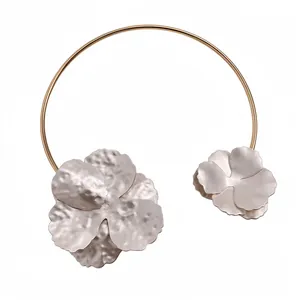 Elegant gold metal neck cuff with textured silver flower charms for women's fashion.
