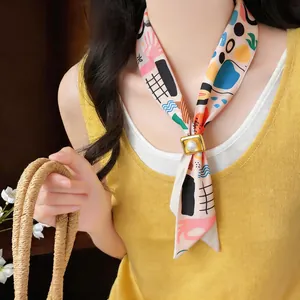 Close-up of a resort-style fabric scarf necklace with a square resin buckle detail